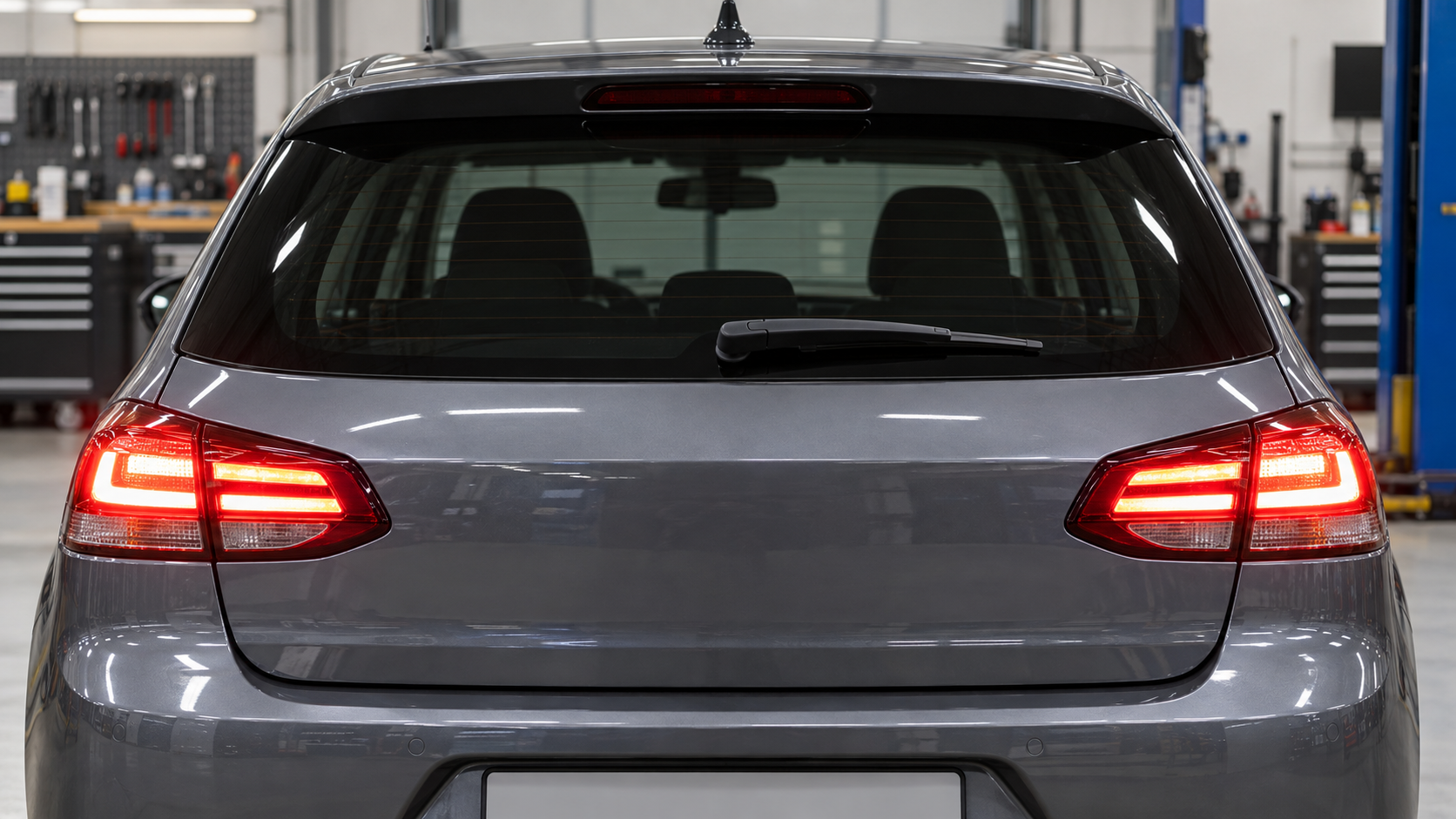 Car rear with both brake lamps illuminated and the center high-mounted stop lamp off